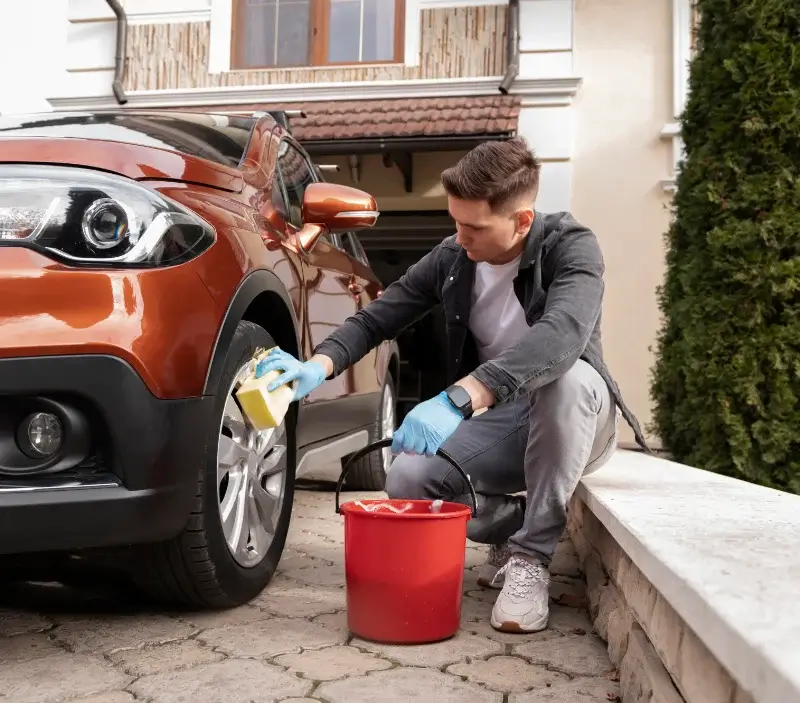 Lavage auto à domicile Saint-Ouen-du-Breuil : professionnel intervenant sur un véhicule